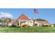 Inviting clubhouse features a red tile roof and a well-manicured lawn under a clear blue sky at 6346 Dallas Blvd, Orlando, FL 32833