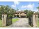 Stately two-story home featuring a gated entrance, a long driveway and a cozy seating area with rocking chairs at 6346 Dallas Blvd, Orlando, FL 32833