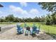 Inviting outdoor space featuring a stone patio with blue rocking chairs gathered around a fire pit at 6346 Dallas Blvd, Orlando, FL 32833