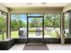 View from the screened porch towards the spacious backyard with a barbecue grill and a lush green lawn at 6346 Dallas Blvd, Orlando, FL 32833