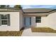 Close-up showcasing the home's entrance with a light blue front door, black shutters, and neutral-colored exterior at 709 Marion Oaks Mnr, Ocala, FL 34473