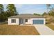Charming single-story home featuring a blue garage door, complemented by a well-manicured lawn and a concrete driveway at 709 Marion Oaks Mnr, Ocala, FL 34473