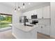Modern kitchen features an island, stainless steel appliances, white cabinets, and a backyard view at 709 Marion Oaks Mnr, Ocala, FL 34473