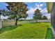 Expansive backyard with a pristine lawn, mature trees, and a white picket fence offers privacy at 7895 Pleasant Pine Cir, Winter Park, FL 32792