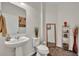 Compact bathroom featuring a pedestal sink, decorative mirror, and stylish fixtures for a functional space at 7895 Pleasant Pine Cir, Winter Park, FL 32792