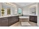 Bright bathroom featuring a corner tub, double sinks, and a separate shower at 7895 Pleasant Pine Cir, Winter Park, FL 32792