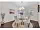Formal dining room featuring a modern chandelier, neutral colors, and hardwood floors at 7895 Pleasant Pine Cir, Winter Park, FL 32792