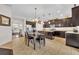 Open kitchen with dark wood cabinetry, a center island, and a dining area, creating a perfect space for cooking and dining at 7895 Pleasant Pine Cir, Winter Park, FL 32792