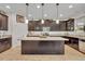 Spacious kitchen features dark cabinets, granite countertops, and a large center island with modern lighting fixtures at 7895 Pleasant Pine Cir, Winter Park, FL 32792
