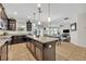 Modern kitchen with dark wood cabinets, stainless steel appliances, and a central island with pendant lighting at 7895 Pleasant Pine Cir, Winter Park, FL 32792