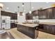 Well-equipped kitchen with dark wood cabinets, granite countertops, stainless steel appliances, and a central island at 7895 Pleasant Pine Cir, Winter Park, FL 32792