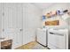 Functional laundry room with a washer, dryer, storage shelves, and door to living area at 7895 Pleasant Pine Cir, Winter Park, FL 32792