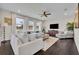 Bright living room features hardwood floors, a modern ceiling fan, and comfortable white furniture with ample natural light at 7895 Pleasant Pine Cir, Winter Park, FL 32792