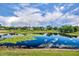 Scenic pond reflecting the sky and trees, surrounded by lush greenery and lily pads at 7895 Pleasant Pine Cir, Winter Park, FL 32792
