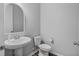 Clean and modern half bathroom featuring a pedestal sink, toilet, and neutral color palette at 840 Livestock Loop, St Cloud, FL 34771
