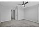 An empty gray bedroom with gray carpeting and a ceiling fan at 840 Livestock Loop, St Cloud, FL 34771