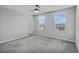 A bedroom with two windows offering neighborhood views and neutral gray carpeting at 840 Livestock Loop, St Cloud, FL 34771
