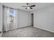 A bright bedroom featuring gray carpet, a window with sheer curtains, and a ceiling fan at 840 Livestock Loop, St Cloud, FL 34771
