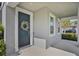 Inviting front door with decorative wreath, complemented by sidelight windows and a covered porch at 840 Livestock Loop, St Cloud, FL 34771