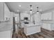 Modern kitchen with white cabinets, island and stainless steel appliances, flowing into living space at 840 Livestock Loop, St Cloud, FL 34771