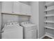 Bright laundry room with modern appliances, white cabinets, and stylish shelving at 840 Livestock Loop, St Cloud, FL 34771