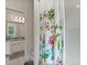Bright bathroom with colorful floral shower curtain and granite countertops visible in the mirror at 9814 Amber Chestnut Way, Winter Garden, FL 34787