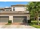 Two-car garage with brick paver driveway and manicured landscaping provides great curb appeal at 9814 Amber Chestnut Way, Winter Garden, FL 34787