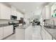 Modern kitchen featuring granite countertops, stainless steel appliances, and white cabinetry in an open space at 9814 Amber Chestnut Way, Winter Garden, FL 34787