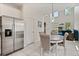 Bright and airy dining area with stainless steel refrigerator adjacent to the modern kitchen at 9814 Amber Chestnut Way, Winter Garden, FL 34787