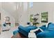 Bright living room with soaring ceilings, large windows, and stylish blue furniture on white tile floors at 9814 Amber Chestnut Way, Winter Garden, FL 34787