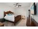 Simple main bedroom with wooden furniture, ceiling fan, and mounted TV at 9814 Amber Chestnut Way, Winter Garden, FL 34787
