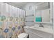Well-lit bathroom featuring a shower with floral curtains, a vanity and large mirror at 999 Mancha Real Dr, Orlando, FL 32807