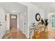 Inviting foyer with wood floors, complemented by a decorative mirror, table, and a stylish front door at 999 Mancha Real Dr, Orlando, FL 32807