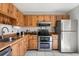 Efficient kitchen with stainless steel appliances, wood cabinets, and a tile backsplash at 999 Mancha Real Dr, Orlando, FL 32807