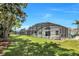 Spacious backyard with lush green grass, mature trees, and a screened-in pool for outdoor relaxation and entertainment at 1019 Lake Berkley Dr, Kissimmee, FL 34746