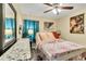Cozy bedroom with a ceiling fan, floral patterned bedding, and ample natural light at 1019 Lake Berkley Dr, Kissimmee, FL 34746