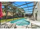 Relaxing screened-in pool area with lounge chairs and lush greenery, perfect for outdoor enjoyment at 1019 Lake Berkley Dr, Kissimmee, FL 34746