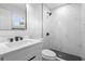 Stylish bathroom with a marble tiled shower, modern fixtures, black hardware and a sleek vanity at 105 E Magnolia St, Davenport, FL 33837
