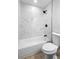 Clean bathroom with a tiled shower, light walls, updated faucet and fixtures and a modern toilet at 105 E Magnolia St, Davenport, FL 33837