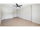 Clean bedroom featuring wood-look floors, ceiling fan, closet and a door to another room at 105 E Magnolia St, Davenport, FL 33837