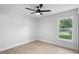Cozy bedroom with a ceiling fan, light walls, and a bright window with a pleasant outdoor view at 105 E Magnolia St, Davenport, FL 33837