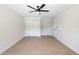 Clean, neutral bedroom with wood-look floors, a ceiling fan, and closet space at 105 E Magnolia St, Davenport, FL 33837