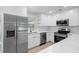 Newly updated kitchen featuring white cabinets, modern stainless steel appliances, and an ample amount of counter space at 105 E Magnolia St, Davenport, FL 33837