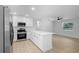 Modern kitchen with an island, stainless appliances and a fan, open to other rooms at 105 E Magnolia St, Davenport, FL 33837