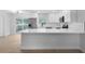 Modern kitchen featuring stainless steel appliances, sleek white cabinetry, quartz countertops, and updated lighting at 105 E Magnolia St, Davenport, FL 33837
