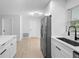 Updated kitchen with white cabinetry, stainless steel appliances, and laminate flooring at 105 E Magnolia St, Davenport, FL 33837