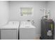 Functional laundry room equipped with a washer, dryer, and water heater at 105 E Magnolia St, Davenport, FL 33837