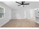 Bright living room with light wood flooring, fresh paint, modern ceiling fan, and ample natural light at 105 E Magnolia St, Davenport, FL 33837