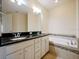 Bathroom features dual sinks, a granite counter and a soaking tub at 10653 Belfry Cir, Orlando, FL 32832
