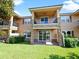 Exterior of a multi-story condo with balconies, lush green lawn, and stone accents at 10653 Belfry Cir, Orlando, FL 32832